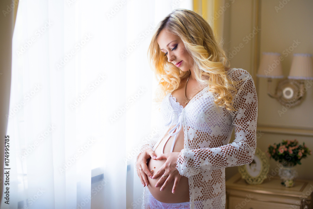 Pregnant belly, hugging the stomach and hands in the shape of the heart Pregnant belly, hugging the stomach and hands in the shape of the heart