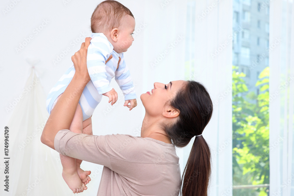Mother holding cute baby after bathing at home