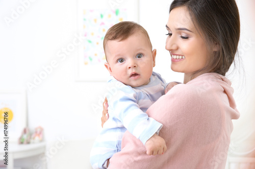 Mother holding cute baby after bathing at home