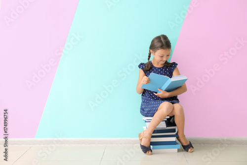 Cute little girl reading bo...