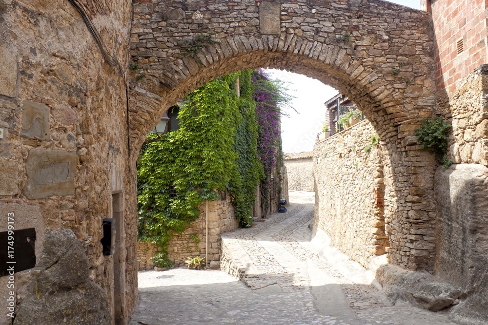 Street and an arch made of stone in Peratallada, Spain