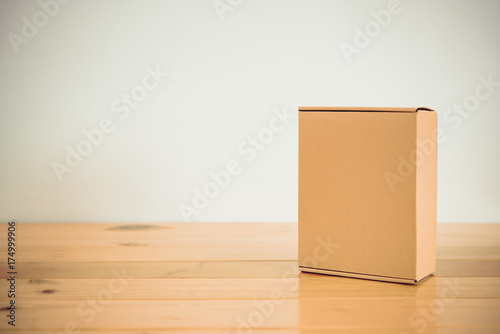 Empty brown cardboard box on wooden table with copy space.