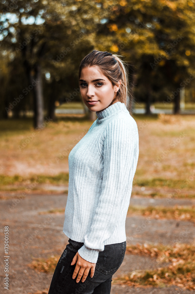 Beautiful woman in casual outfit standing in a park in autumn. Beautiful woman in casual outfit standing in a park in autumn.