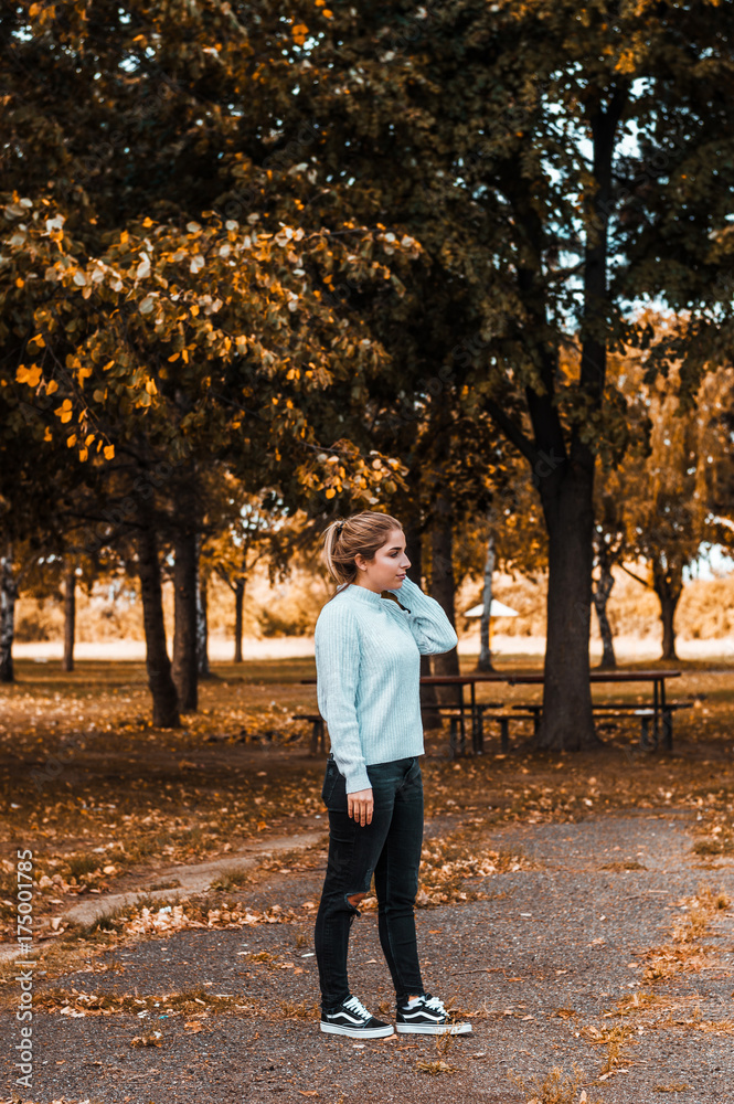 Full length of woman in park, fall background. Full length of woman in park, fall background.
