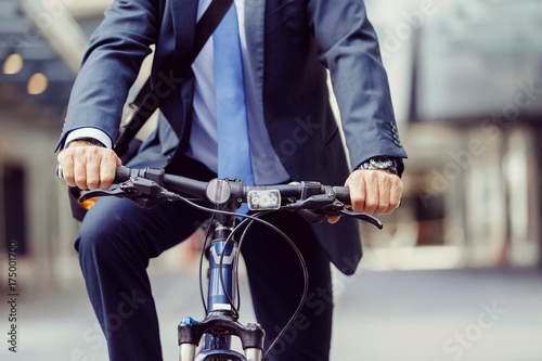 Successful businessman riding bicycle