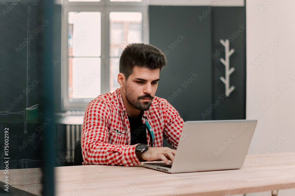 Handsome businessman working with laptop in office. Handsome businessman working with laptop in office.