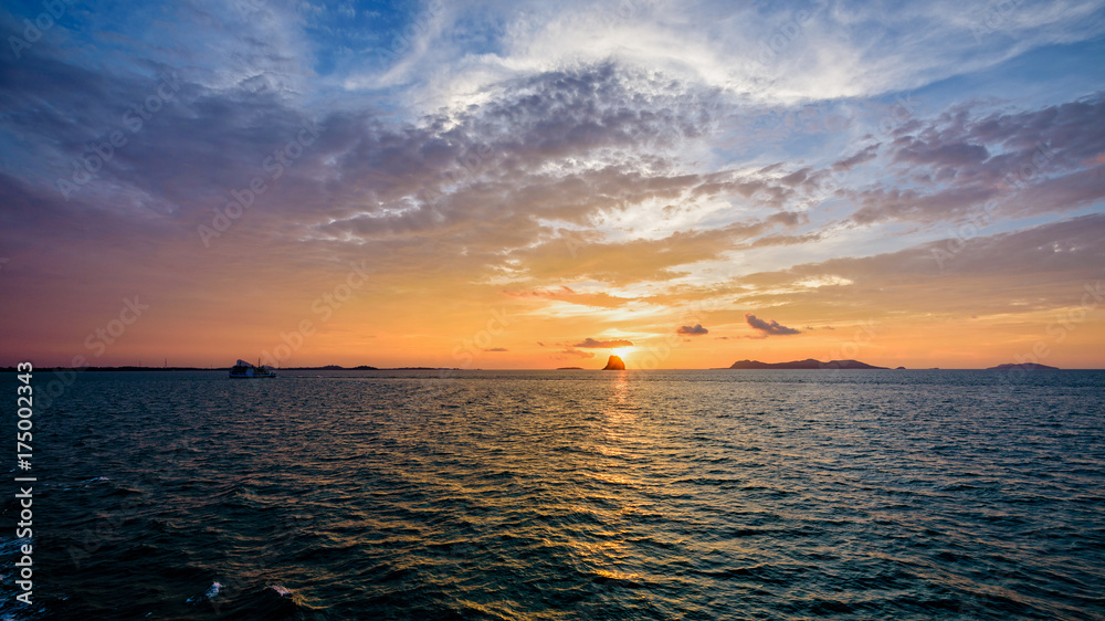 Beautiful natural landscape of colorful cloud sky and sun at sunset over the sea in Surat Thani province, Thailand, 16:9 widescreen