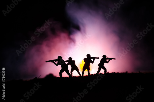 Military silhouettes of soldiers against the backdrop of dark foggy sky. Battle scene with explosion and burning clouds behind fighing soldiers. Toy decoration