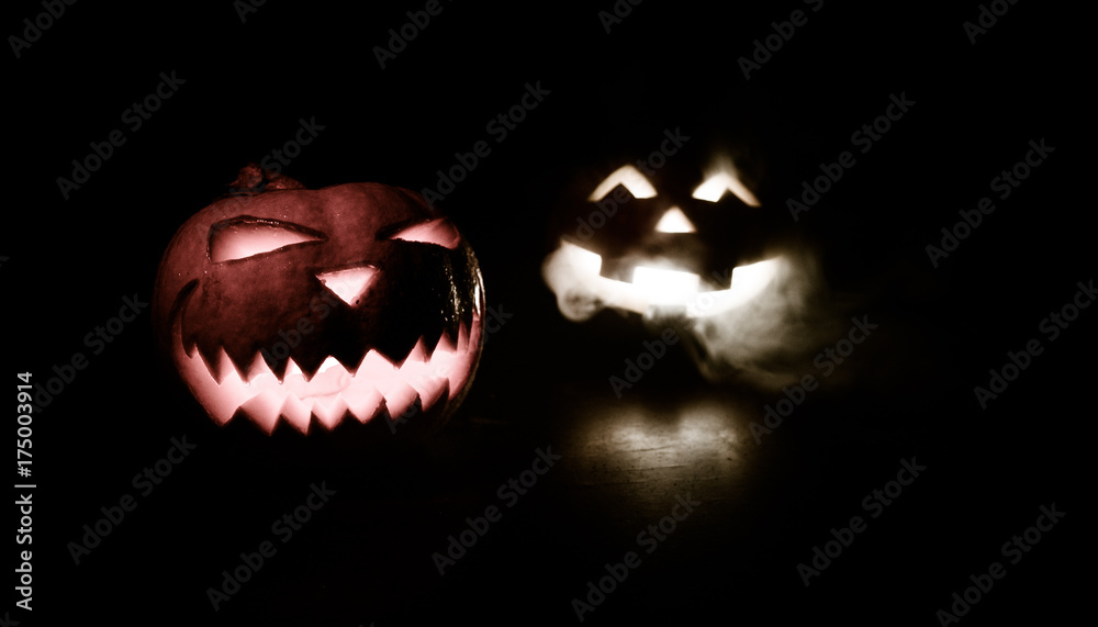 Fototapeta premium Halloween - old jack-o-lantern on black background. Closeup of scary halloween pumpkins