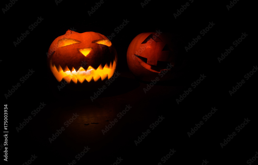 Halloween - old jack-o-lantern on black background. Closeup of scary halloween pumpkins Halloween - old jack-o-lantern on black background. Closeup of scary halloween pumpkins