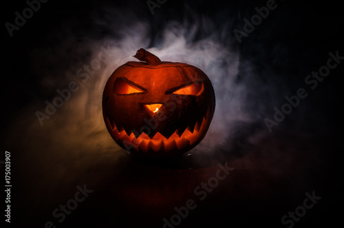 Halloween - old jack-o-lantern on black background. Closeup of scary halloween pumpkins