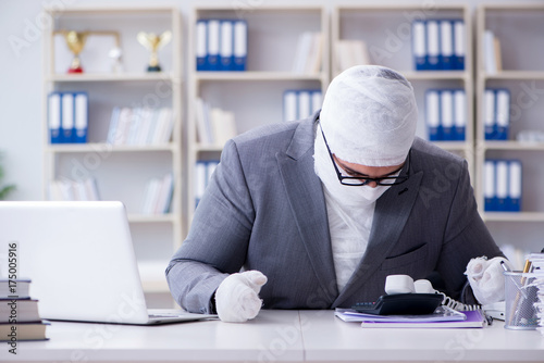 Bandaged businessman worker working in the office doing paperwor