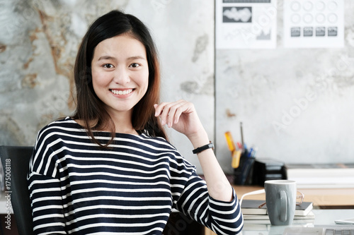 Young asian businesswoman working with with smiling face at office desk, positive emotion, office life concept