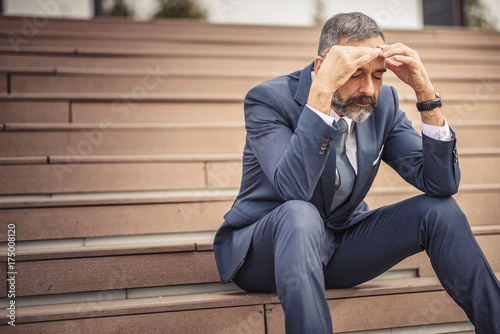 Photos Stressed and overwhelmed senior businessman is trying to release the tension
