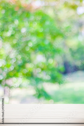 Empty white wood table over blurred tree with bokeh background, for product display montage © mangpor2004