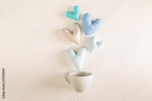 Handmade heart cushions with coffee cups on a white background