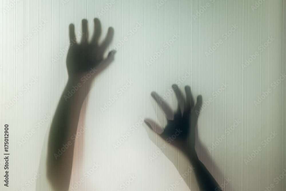 Halloween hands behind transparent glass background as silhouette Halloween hands behind transparent glass background as silhouette