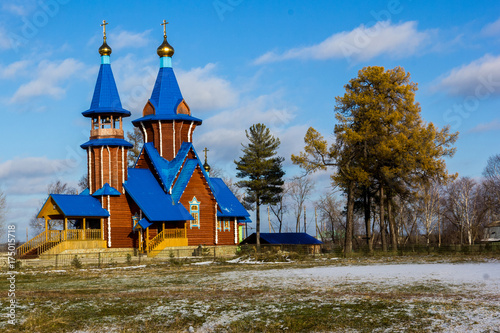 the Church of wood with a blue roof near trees photo