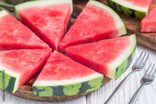 Slices of fresh seedless watermelon cut into triangle shape on wooden plate, horizontal