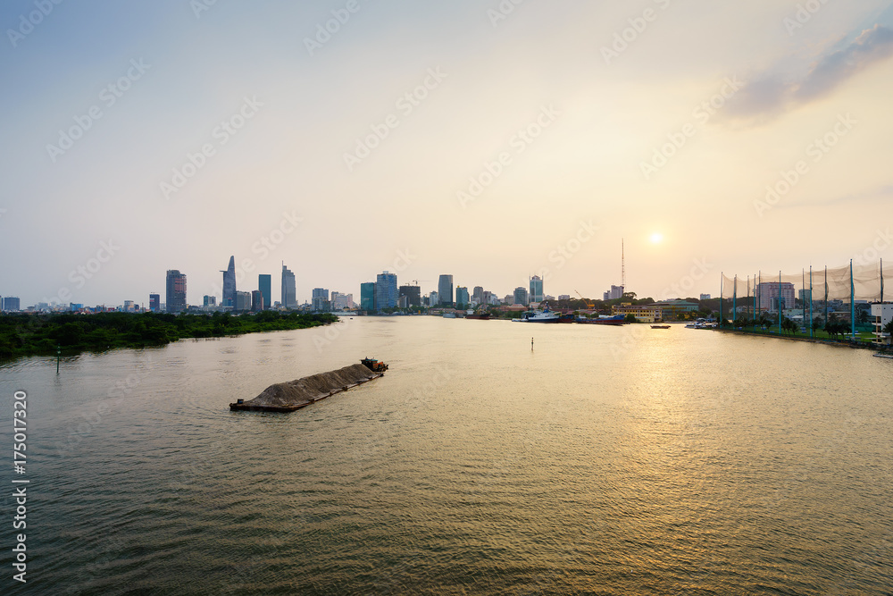 Barge on Saigon river in sunset, Ho Chi Minh city, Vietnam. Ho Chi Minh city (aka Saigon) is the largest city and economic center in Vietnam with population around 10 million people