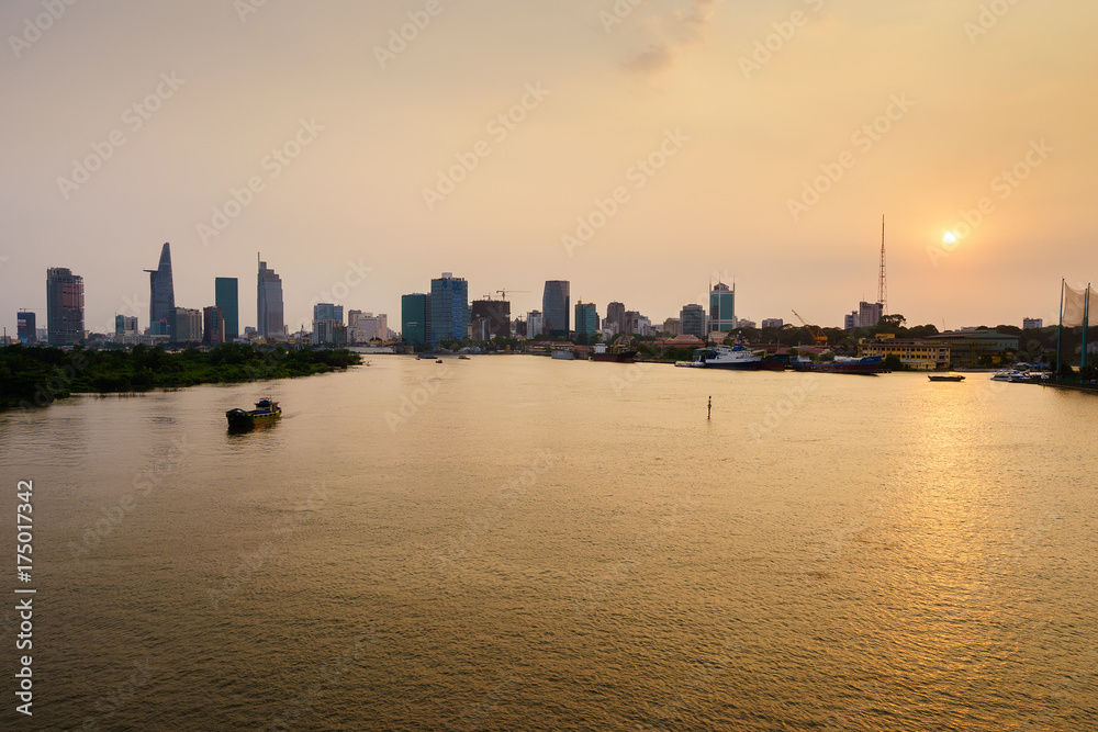 Boat on Saigon river in sunset, Ho Chi Minh city, Vietnam. Ho Chi Minh city (aka Saigon) is the largest city and economic center in Vietnam with population around 10 million people