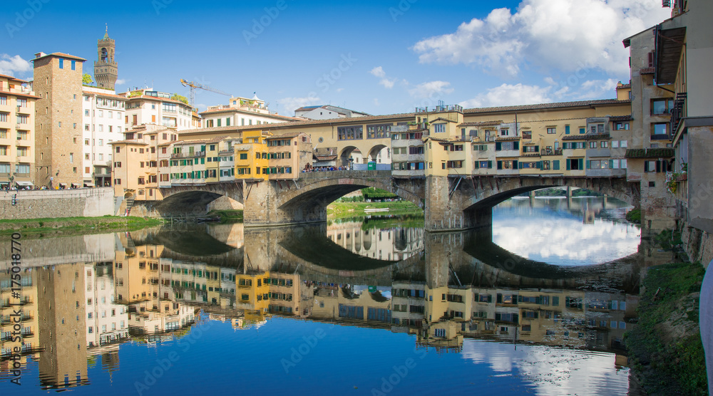 The Ponte Vecchio bridge reflected in the River Arno in Florence 