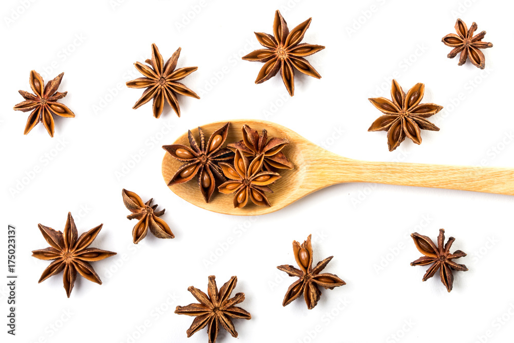 Close up the brown star anise spice in wooden spoon isolated on white background and star anise pattern decoration Close up the brown star anise spice in wooden spoon isolated on white background and star anise pattern decoration