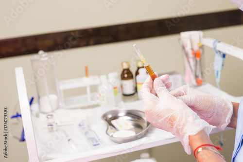 Doctor with syringe in hand. Medical health professional holding a vaccine injection. Concept of vaccination against flu and Viral Diseases. © satura_