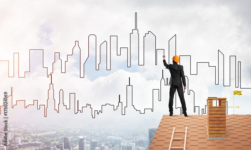 Man architect draw silhouette of modern city on blue sky. Mixed media