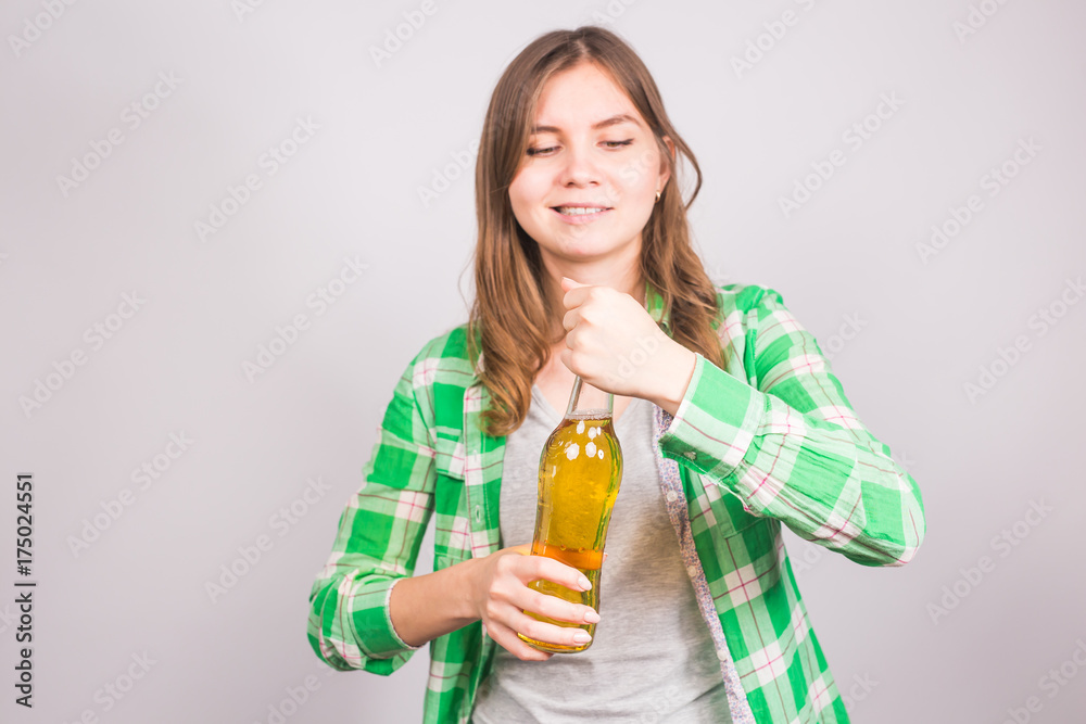 Young woman opens a bottle of beer. Concept of bad habits and alcoholism Young woman opens a bottle of beer. Concept of bad habits and alcoholism