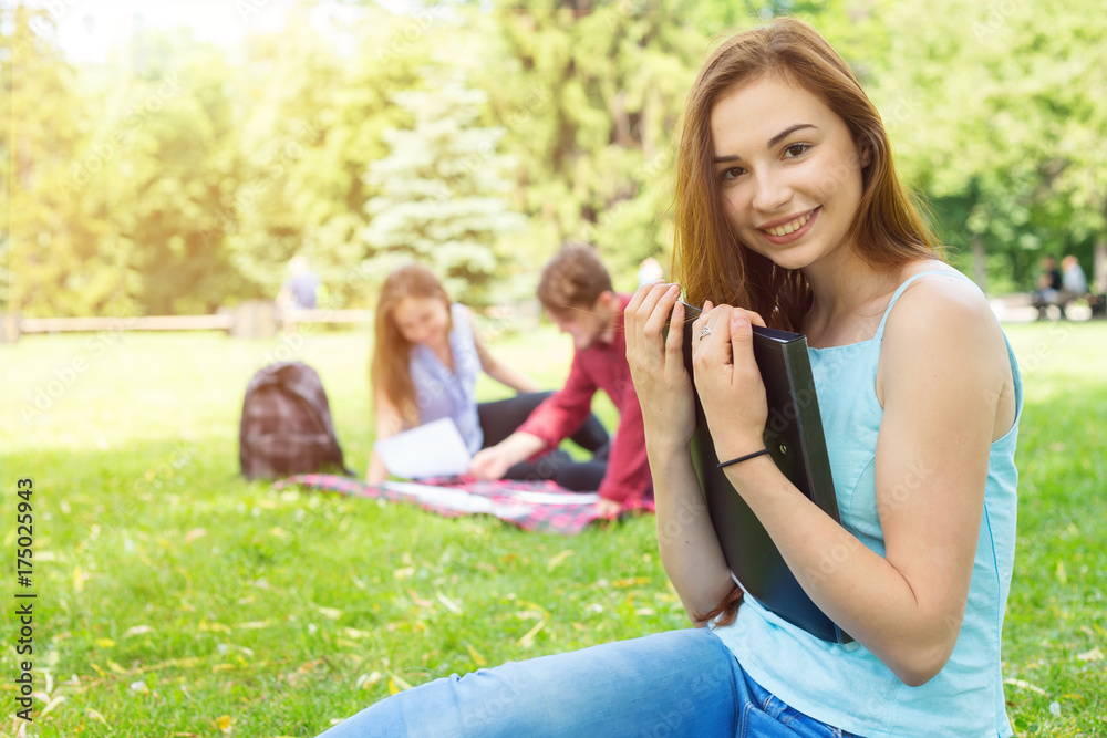 Happy student woman. Young female holding a folder with documents to study. Student life everyday. Happy student woman. Young female holding a folder with documents to study. Student life everyday.