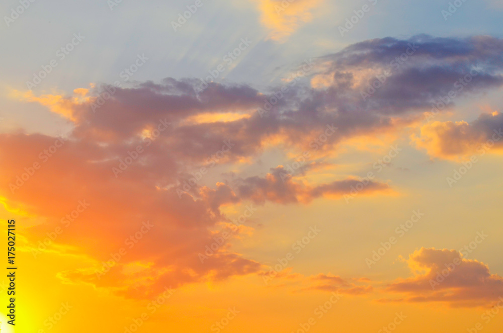 Fototapeta premium Beautiful sunset yellow and orange sky with clouds and sunshine on a sunny day in summer