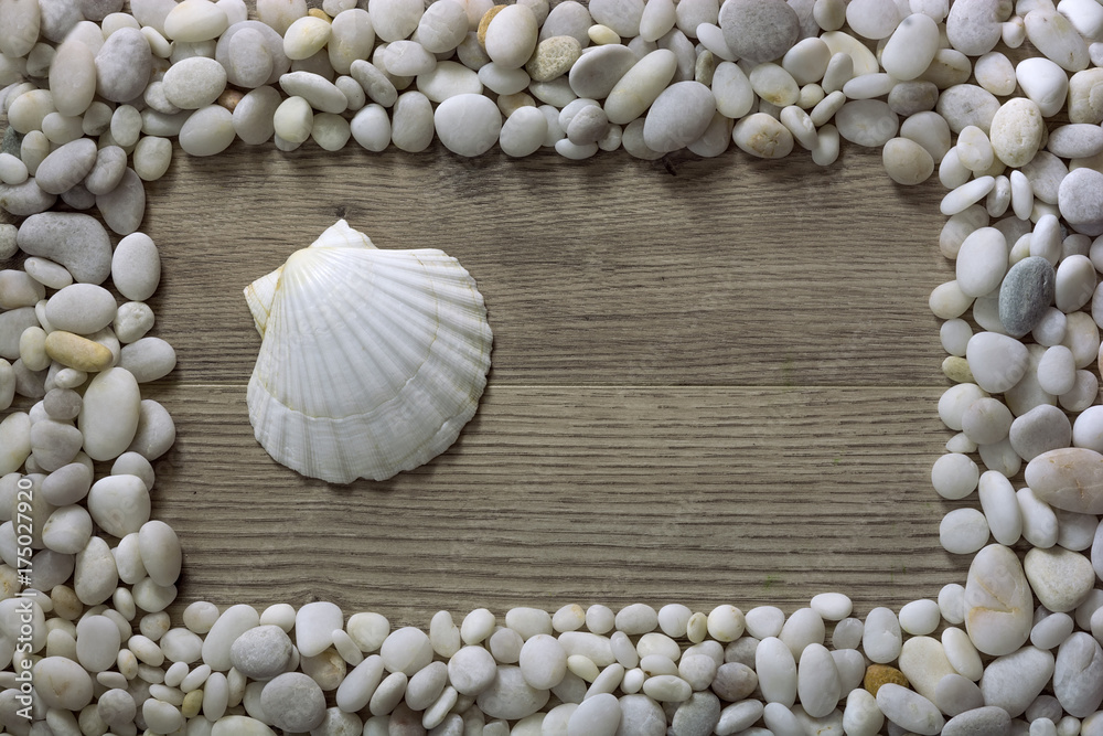 Frame from seashells and stones. Frame made of shells isolated on wooden background