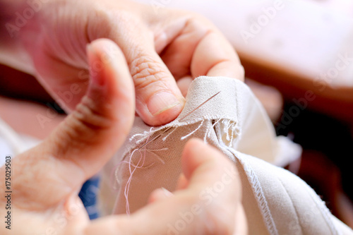 hands of seamstress at work on the wooden chair with her cloth , hand made soft Fototapet