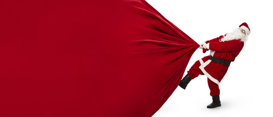 Santa Claus pulling huge bag of presents isiolated on white background with copy space