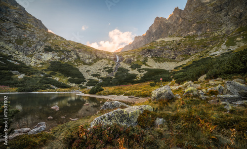 Mountain Lake with Waterfall and Rocks in Foreground at Sunset. Velicka Valley, High Tatra, Slovakia. photo