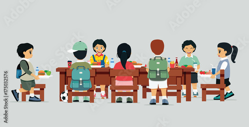 Male and female students are sitting at the table with lunch.