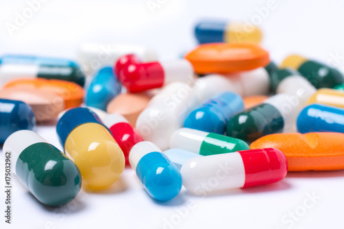 colored pills and capsule on white background photo