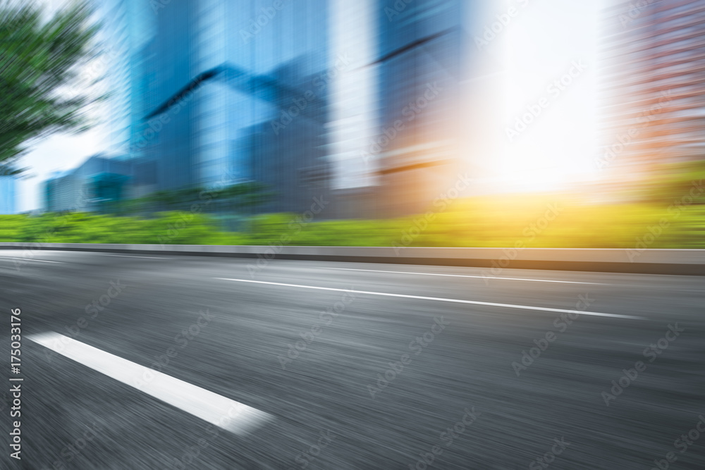 blurred empty urban road and modern buildings at a sunny day