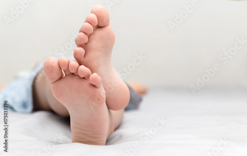 little girl's feet who sleeps in her bed photo