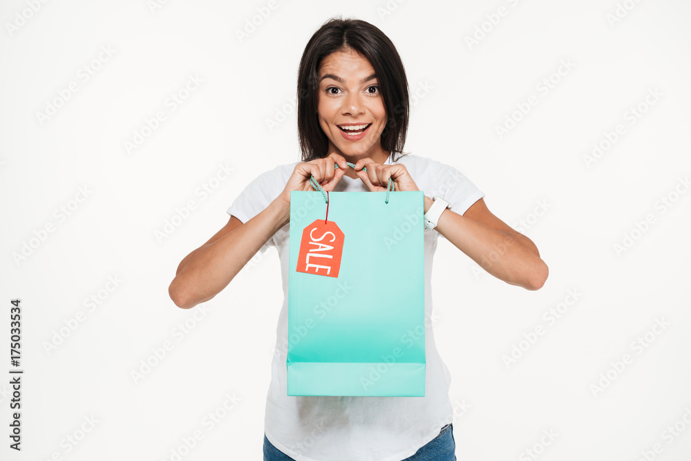 Portrait of an excited young woman holding sale shopping bag Portrait of an excited young woman holding sale shopping bag