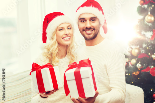 happy couple at home with christmas gift boxes