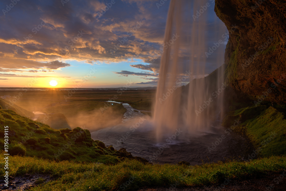 Blick hinter dem Wasserfall zum Sonnenuntergang