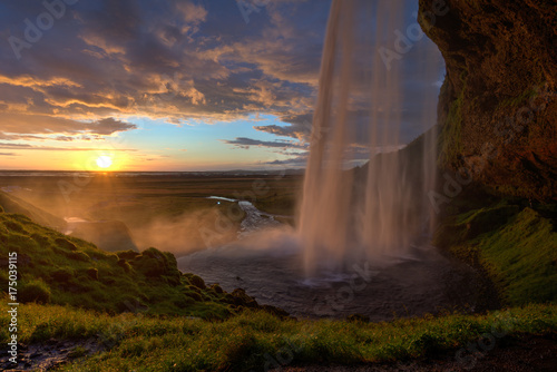 Fototapeta Naklejka Na Ścianę i Meble -  Blick hinter dem Wasserfall zum Sonnenuntergang