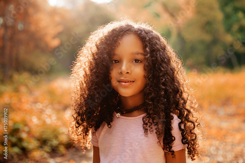 Outdoor portrait of a cute afro american happiness little girl with curly hairl.