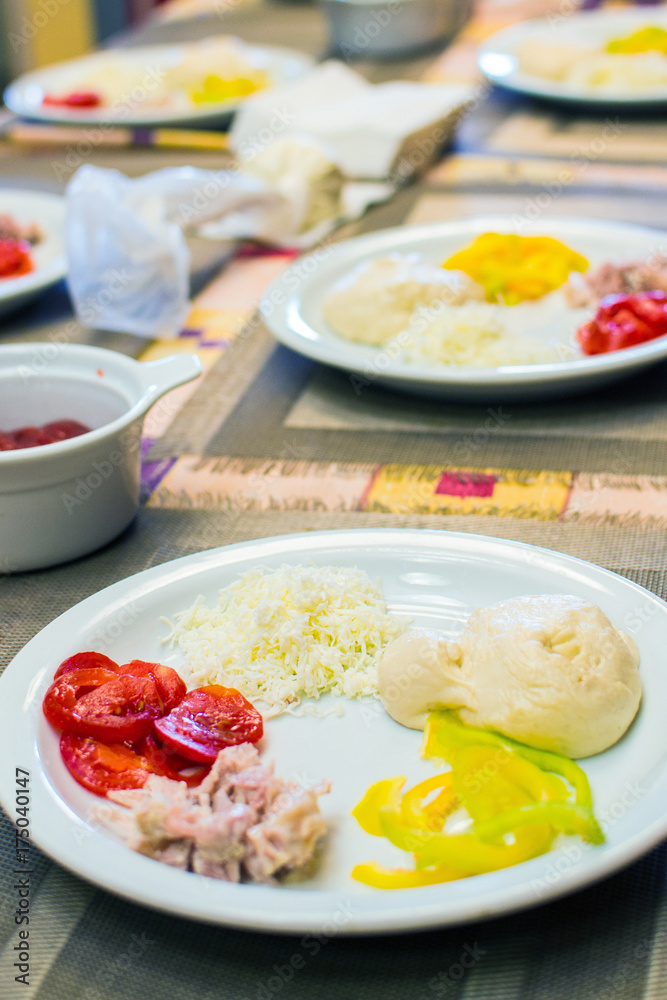 children cook pizza from raw ingredients