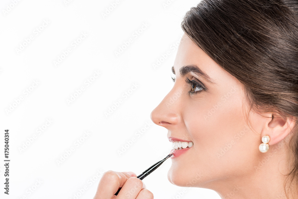 makeup artist applying lipstick on model