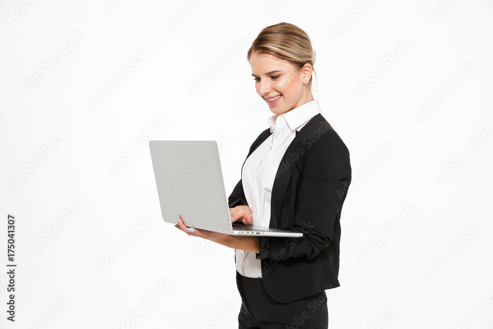 Side view of smiling blonde business woman using laptop computer Side view of smiling blonde business woman using laptop computer