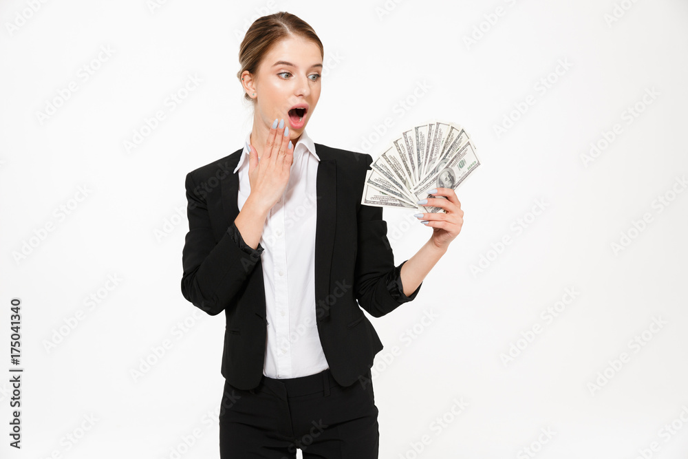 Shocked blonde business woman holding money and looking on their Shocked blonde business woman holding money and looking on their