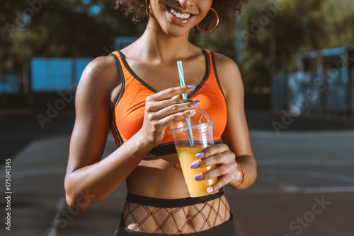 athletic african-american woman drinking juice